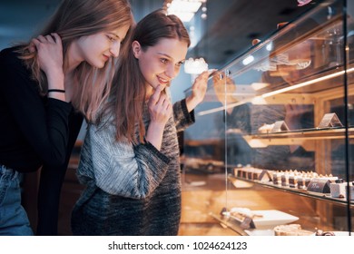 Two happy attractive girls choosing delicious ganaches, praline and chocolates. - Powered by Shutterstock