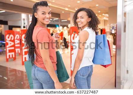 Two happy women shopping together in the city