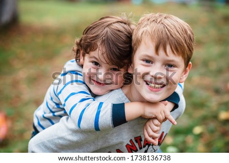 Two happy boys, happy brothers who are smiling happily together. Brothers play outdoors in summer, best friends. Little brother with brother on his back. Two brothers in the woods. Fraternal relations ストックフォト © 