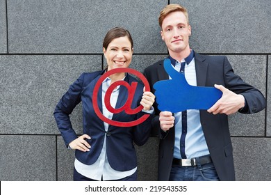 Two Happy Business People Holding Email Sign And Big Like Thumbs Up Symbol