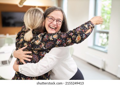 Two Happy Business Women Hugging To Say Hello Or Celebrating A Promotion