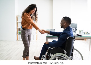 Two Happy Businesspeople In Office Shaking Hands