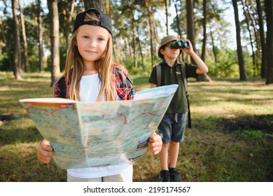 Two Happy Children Having Fun During Forest Hike On Beautiful Day In Pine Forest. Cute Boy Scout With Binoculars During Hiking In Summer Forest. Concepts Of Adventure, Scouting And Hiking Tourism.