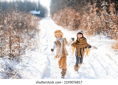 Two happy children are running on a snowy road in winter. Family on a winter walk.