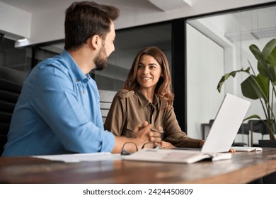 Two happy colleagues man and woman talking at work. Smiling professional business people using laptop having conversation working in office discussing corporate strategy at workplace. - Powered by Shutterstock