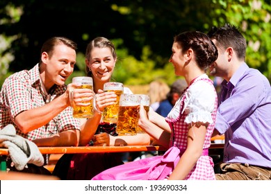 Two Happy Couple Sitting In Bavarian Beer Garden And Enjoy The Beer And The Sun