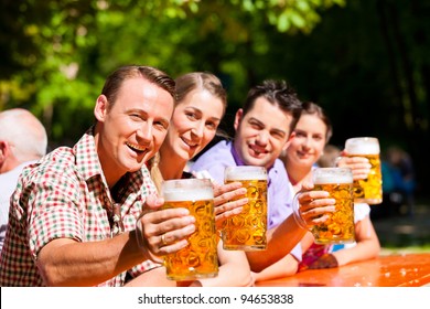 Two Happy Couple Sitting In Beer Garden And Enjoy The Beer And The Sun