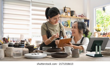 Two Happy Craft Pottery Shop Owners Checking Product Purchase Order On Laptop. Small Business And Art Shop Ownership