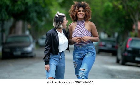 Two Happy Diverse Friends Walking Together Outside In Street Laughing And Smiling Together