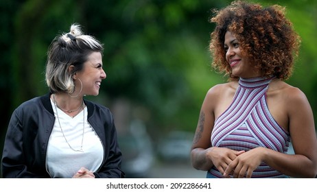 Two Happy Diverse Friends Walking Together Outside In Street Laughing And Smiling Together