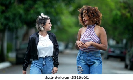 Two Happy Diverse Friends Walking Together Outside In Street Laughing And Smiling Together