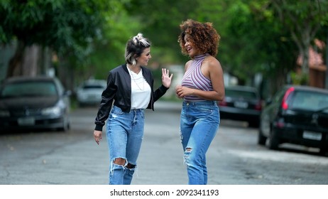 Two Happy Diverse Friends Walking Together Outside In Street Laughing And Smiling Together