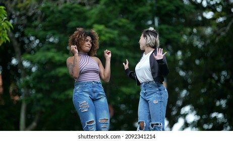 Two Happy Diverse Friends Walking Together Outside In Street Laughing And Smiling Together