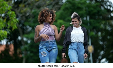 Two Happy Diverse Friends Walking Together Outside In Street Laughing And Smiling Together