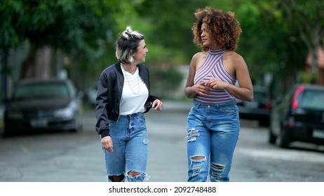 Two Happy Diverse Friends Walking Together Outside In Street Laughing And Smiling Together