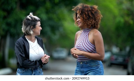 Two Happy Diverse Friends Walking Together Outside In Street Laughing And Smiling Together