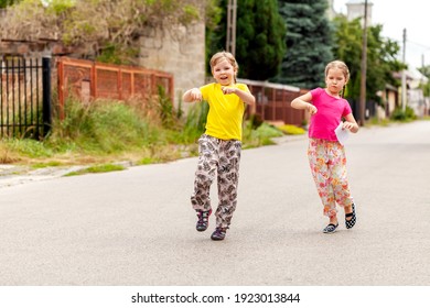 Two Happy Elementary School Age Girls, Children Dancing, Jumping, Walking Through The Street Together. Happiness, Kids Youth Childhood Energy Abstract Concept, Summer Outdoors Activity, Cool Attitude