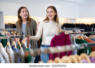 Two happy female friends are shopping in a clothing store. Shopping young ladies - Powered by Shutterstock