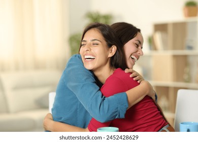 Two happy friends are hugging and laughing at home - Powered by Shutterstock