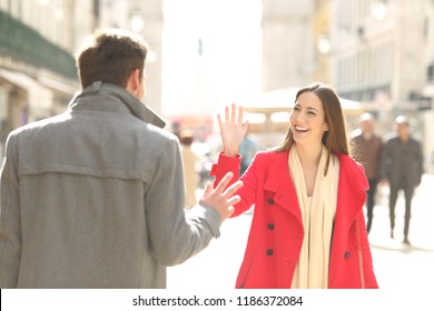 Two happy friends meeting and greeting in the street of a big city - Powered by Shutterstock