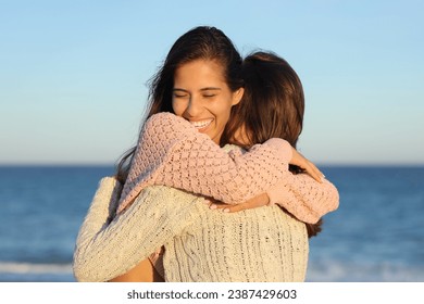 Two happy friends meeting and hugging on the beach at sunset - Powered by Shutterstock