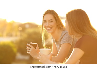 Two Happy Friends Talking Outside In A House Balcony At Sunset
