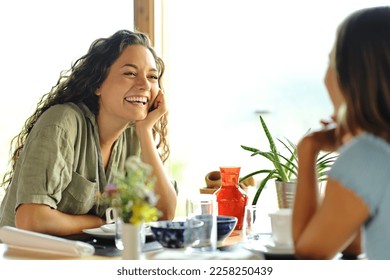 Two happy friends talking in a restaurant