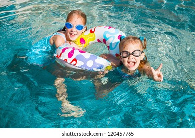 Two Happy  Girls  In The Pool  With Rubber Ring