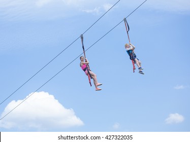 Two Happy Kids Playing On A Zip Line View From Below 