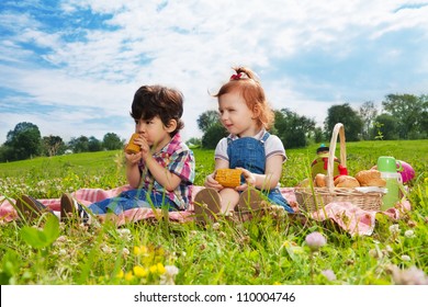 Two Happy Kids Sitting On Picnic In The Park