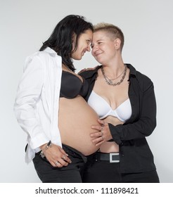 two happy lesbian women, one of them pregnant, happy becoming a family