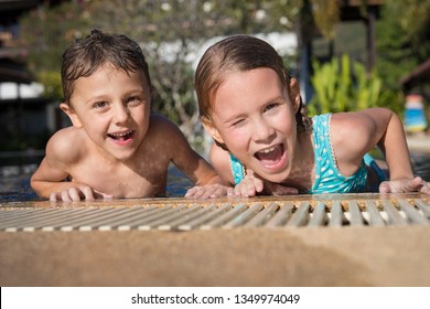 Two Happy Little Children Playing On The Swiming Pool At The Day Time.  Kids Having Fun Outdoors. Concept Of Kids On Vacation And Friendly Family.