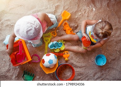 Two Happy Little Kids Playing With Different Colorful Sand Toys. With Fun And Joy Spending Holidays On The Beach Resort. Active Summer Games. Sandbox Playground. Flat Lay.