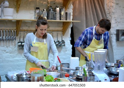 Two Happy Man And Woman Cooking And Talking In The Kitchen. Culinary, Food And People Concept/A Couple Cook On The Kitchen. Cooking Class.