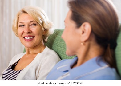 Two Happy Mature Women Talking At Home 