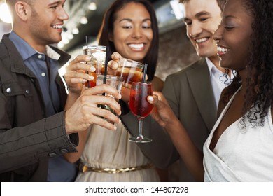 Two happy multiethnic couples toasting drinks at the bar - Powered by Shutterstock