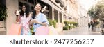 Two Happy Multiethnic Girlfriends Walking With Shopping Bags On City Street, Young Cheerful Women Carrying Purchases And Drinking Takeaway Coffee, Enjoying Seasonal Sales, Copy Space