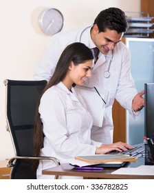 Two Happy Professional Doctors Brainstorming And Sharing Information In Clinic