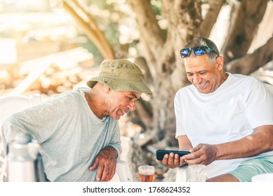 Two Happy Senior Men Baby Boomers Friends Having Fun Use Smart Phone. Active And Healthy Lifestyle.