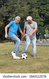 Two happy senior men playing the football at park outdoor