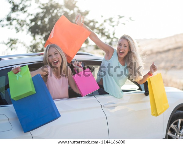 Two\
happy sister in car happy and smiling after\
shopping