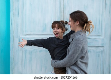 Two happy sisters next to a blue door in the village of Altea in the province of Alicante, Spain. - Shutterstock ID 1017204166