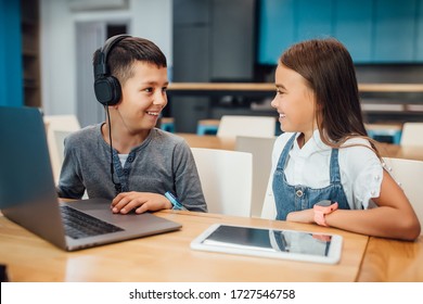 Two Happy Small Friends, Boy And Girl Using Smart Digital Tablet For Playing At Modern Blue Room.