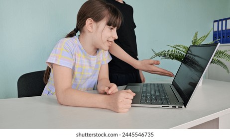 Two happy smiling interested teenager classmates working together watching educational video using laptop computer during lesson in class. Modern technologies for education - Powered by Shutterstock