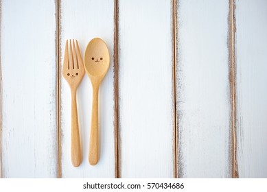 Two happy spoon and fork on wood texture of dining table. Concept about happiness and friendship.