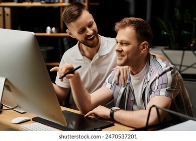 Two happy, stylishly dressed men working together in a modern office, focused on a computer screen. - Powered by Shutterstock