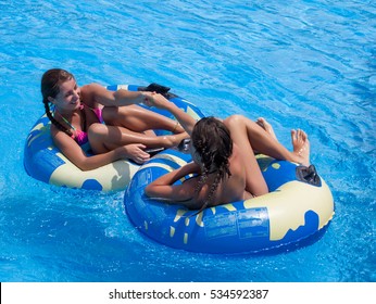 Two Happy Teen Girls Having Fun In The Swimming Pool