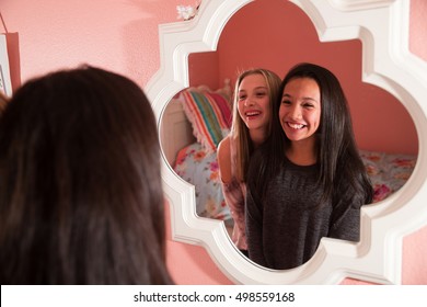 Two Happy Teen Girls Looking In Mirror