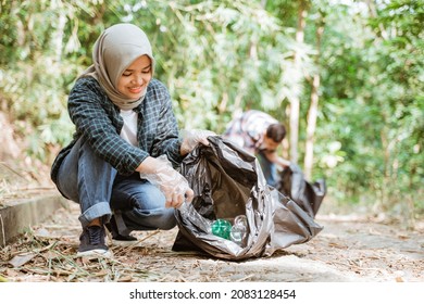 Two Happy Teenage Volunteers Picking Up Trash