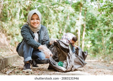 Two Happy Teenage Volunteers Picking Up Trash